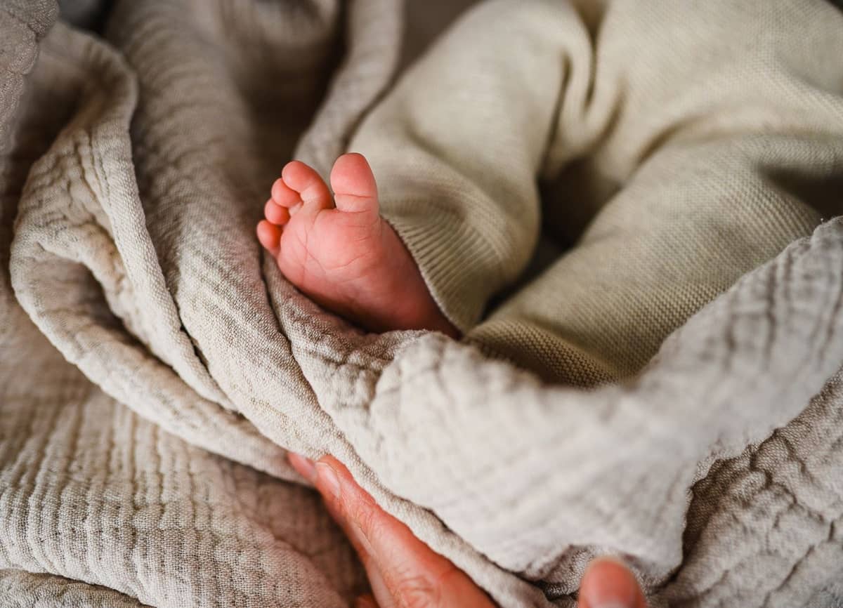 Kleine Babyfüße auf einer weichen Strickdecke