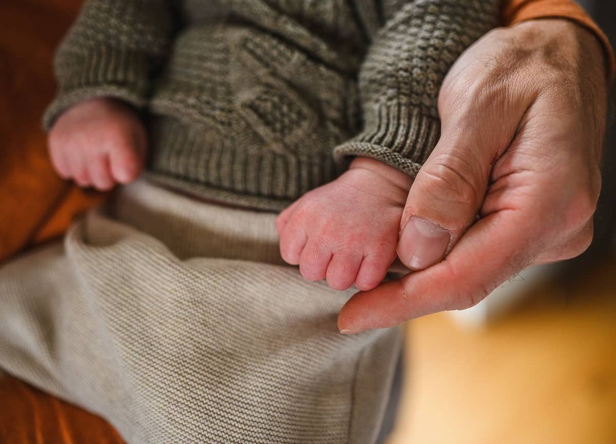 Babyfüßchen in einer großen Hand