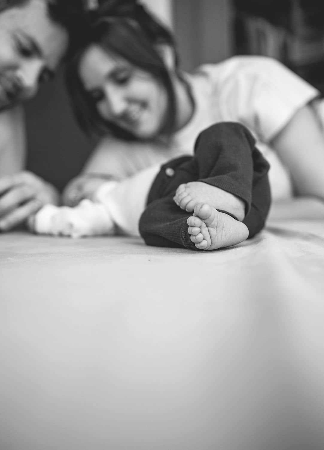 Schwarzweißbild, Mama beugt sich lächelnd über ihr Baby