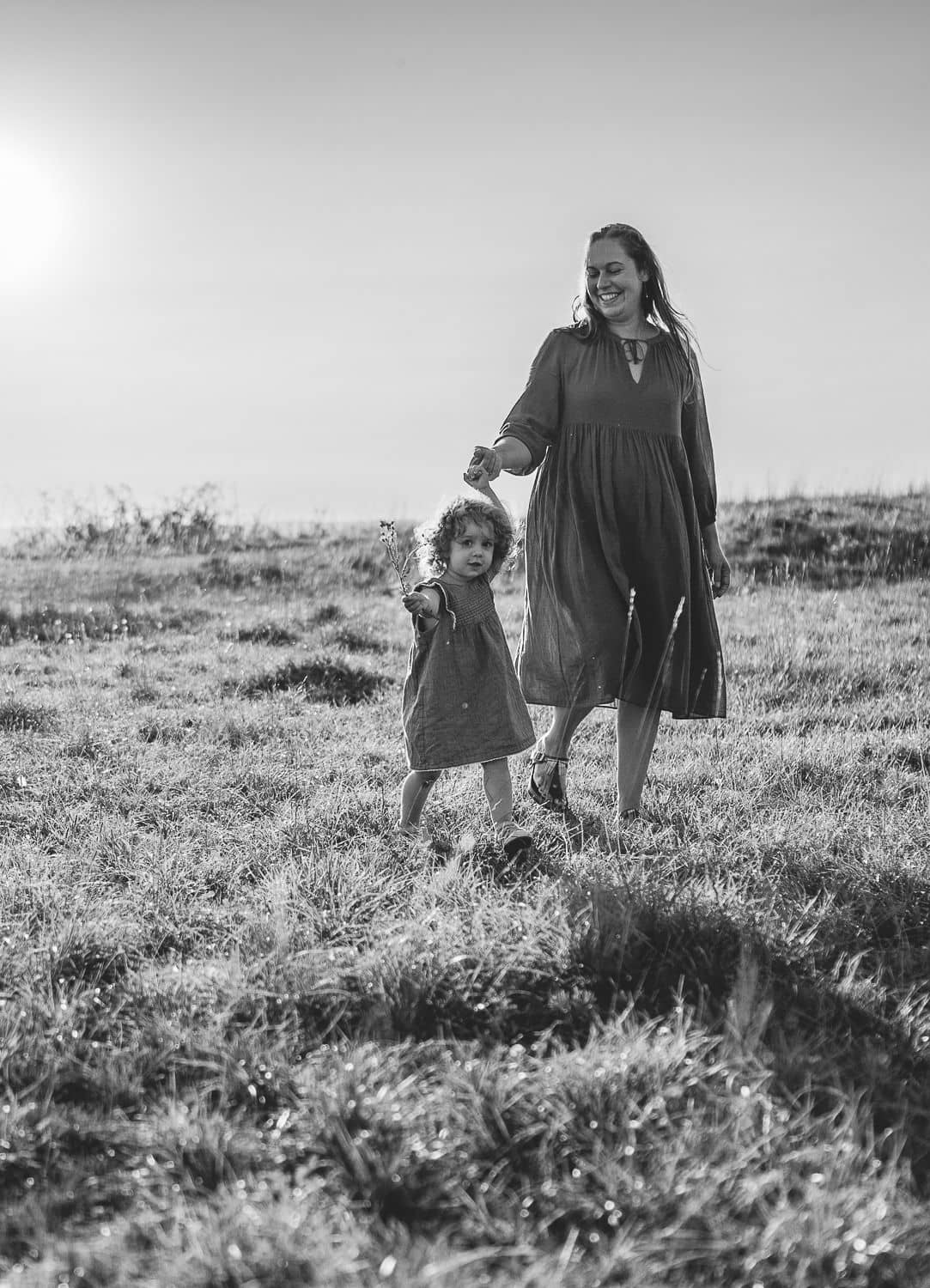 Schwarzweißbild, Mama geht mit ihrer Tochter über eine Wiese